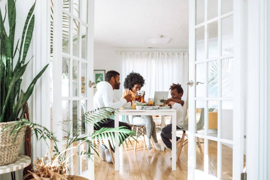 Family enjoying a meal at a dining table in a bright, modern home, emphasizing family connections and home life.